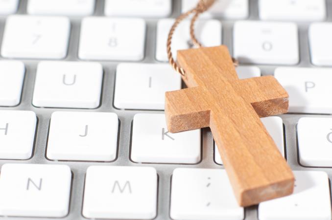 Christian cross necklace on computer keyboard