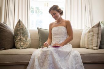 Beautiful bride writing in planner