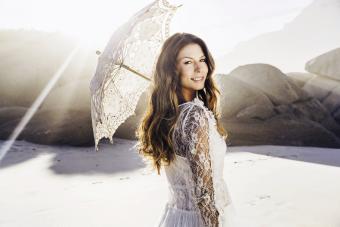 Bride holding parasol looking over her shoulder