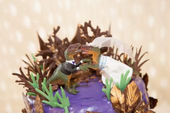 Chocolate cake with dinosaur bride and groom toppers