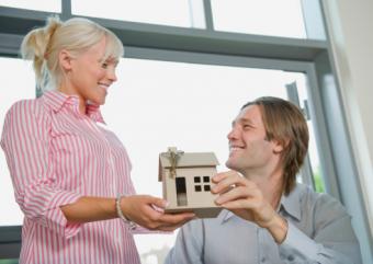 Couple holding model of a house