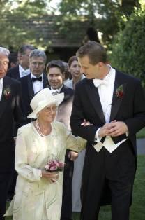 Groom escorting his grandmother to her table