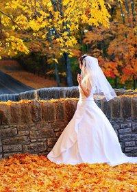 A bride strolling through autumn leaves in the park