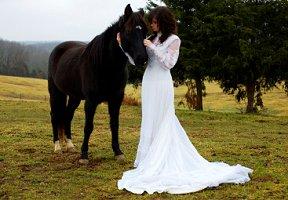 A bride petting a horse in a field