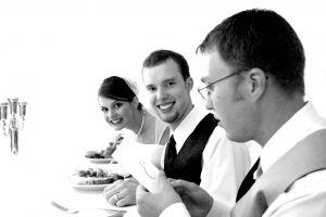 Bride, groom and best man having dinner