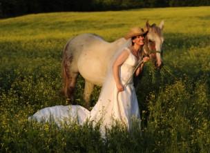Bride walking through a field with her horse