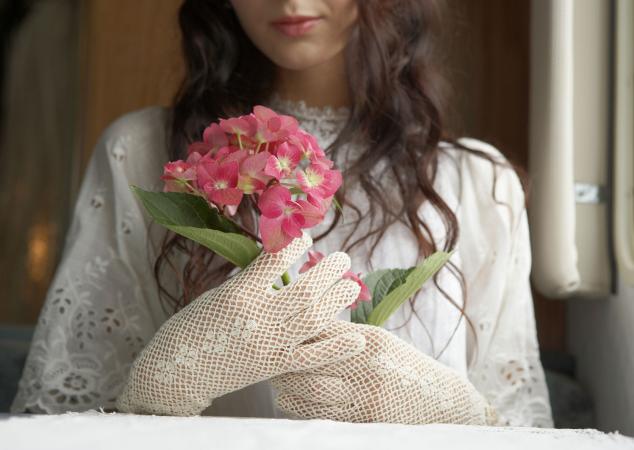 Bride holding pink hydrangeas at window