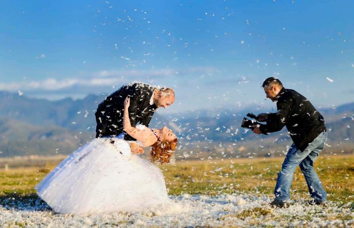 happy grooms posing and videographer working