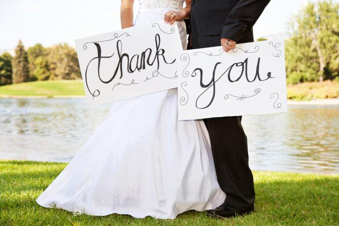 Young Wedding Couple Holding Thank You Signs