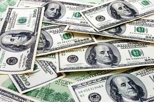 A pile of $100 bills on a tabletop