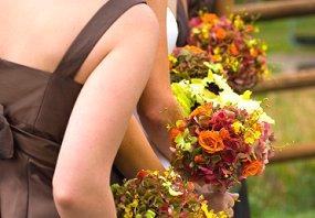 Bridesmaids in brown dresses and carrying autumn bouquets