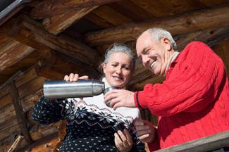 Senior couple standing on balcony of log cabin