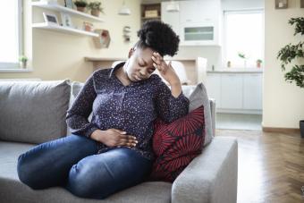 woman on sofa with stomach pain