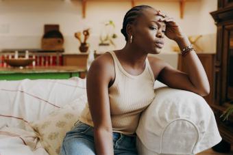 woman sitting on sofa dealing with a stressful situation