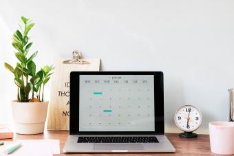 Opened laptop with a calendar on desk at home office