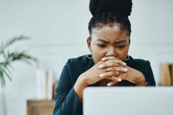 businesswoman frowning while using a laptop 