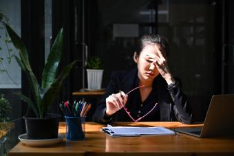 Overworked businesswoman take off glasses and massaging her head