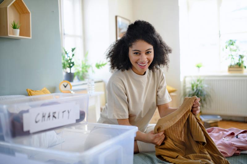 Young woman sorting wardrobe at home