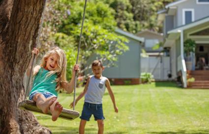 brother and sister playing on the swing