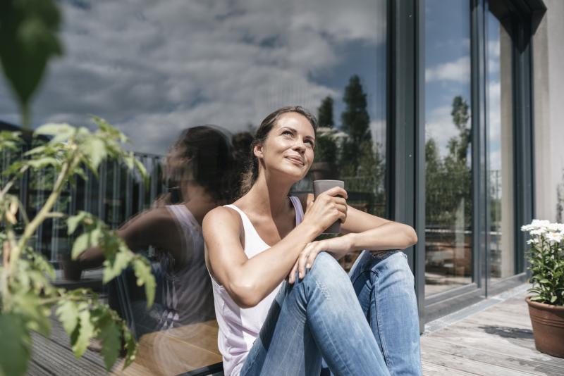woman sitting in the sun on her balcony