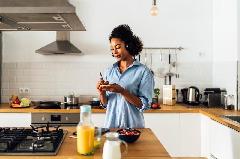 Woman in her kitchen writing notes