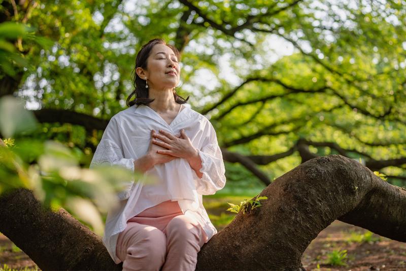 person meditating in forest