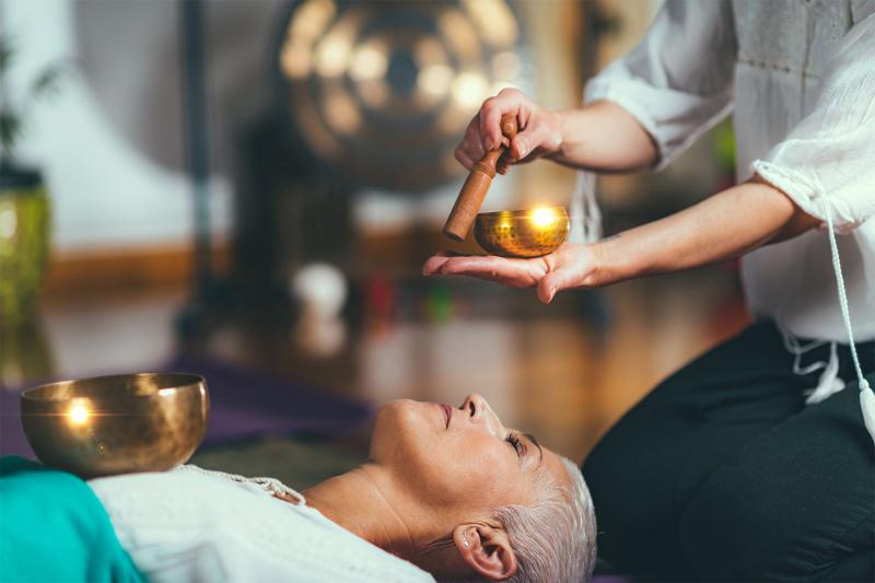 person getting sound bath by hearing singing bowl