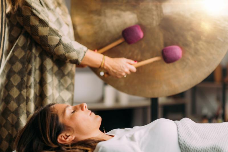 person receiving gong therapy for health wellness