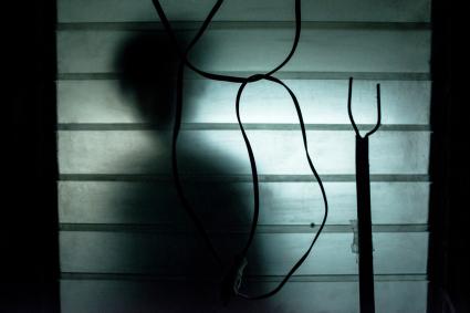 A silhouette of a person outside a window