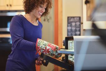 A woman using a countertop oven in her home kitchen