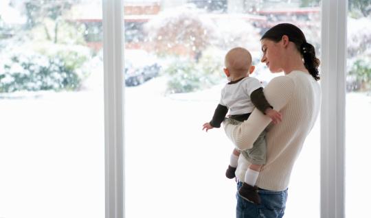 Mother and baby looking out window