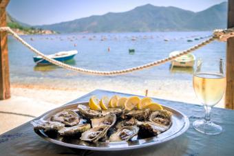 Oysters in a white plate with lemon and a glass of wine