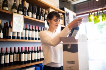 woman packing bottle of wine for shipping