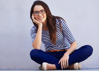 Classically styled smiling woman sitting on floor