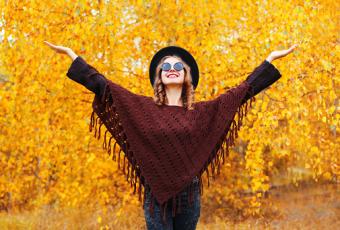 Woman wearing knitted burgundy poncho