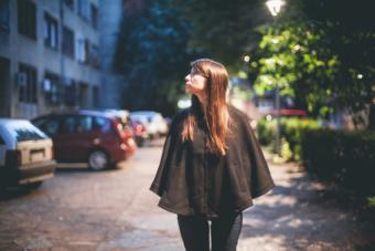 Girl wearing black poncho at night