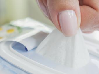 woman's hand pulling out baby wipe