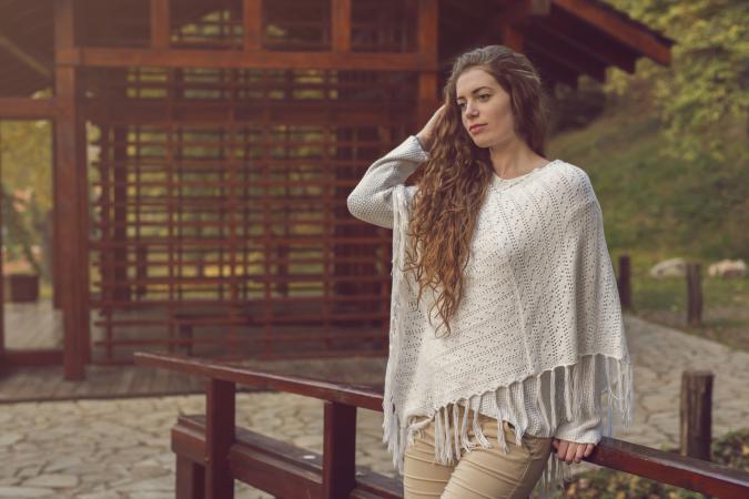 Woman wearing knit poncho outdoors