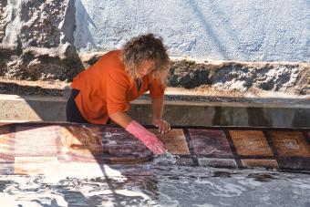 woman washing an indoor-outdoor carpet