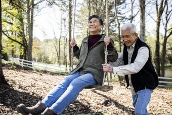 man pushing his wife on a swing