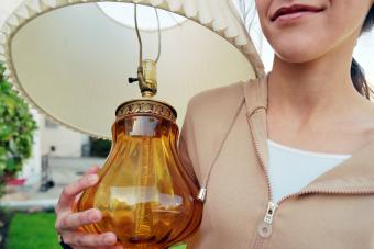 Girl carrying a vintage lamp with a smile on her face