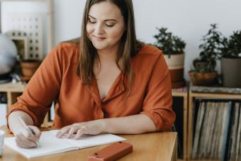 Woman Sitting in her Living Room and Writing a Diary