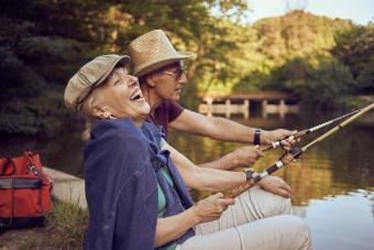 Senior couple laughing while fishing in lake