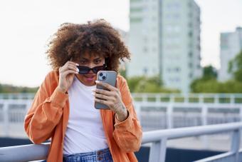 woman wearing sunglasses and looking at her mobile phone