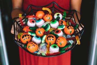 Woman at the front door offering funny Halloween candies