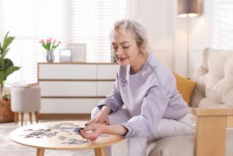 Elderly woman works on a jigsaw puzzle