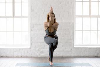 Woman practicing yoga, standing in Eagle pose