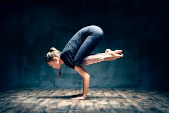 Young woman practicing yoga doing forearm stand crane pose