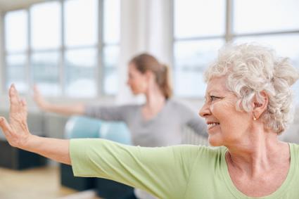 Elderly woman at yoga class