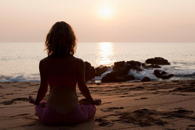 Woman practicing yoga on beach